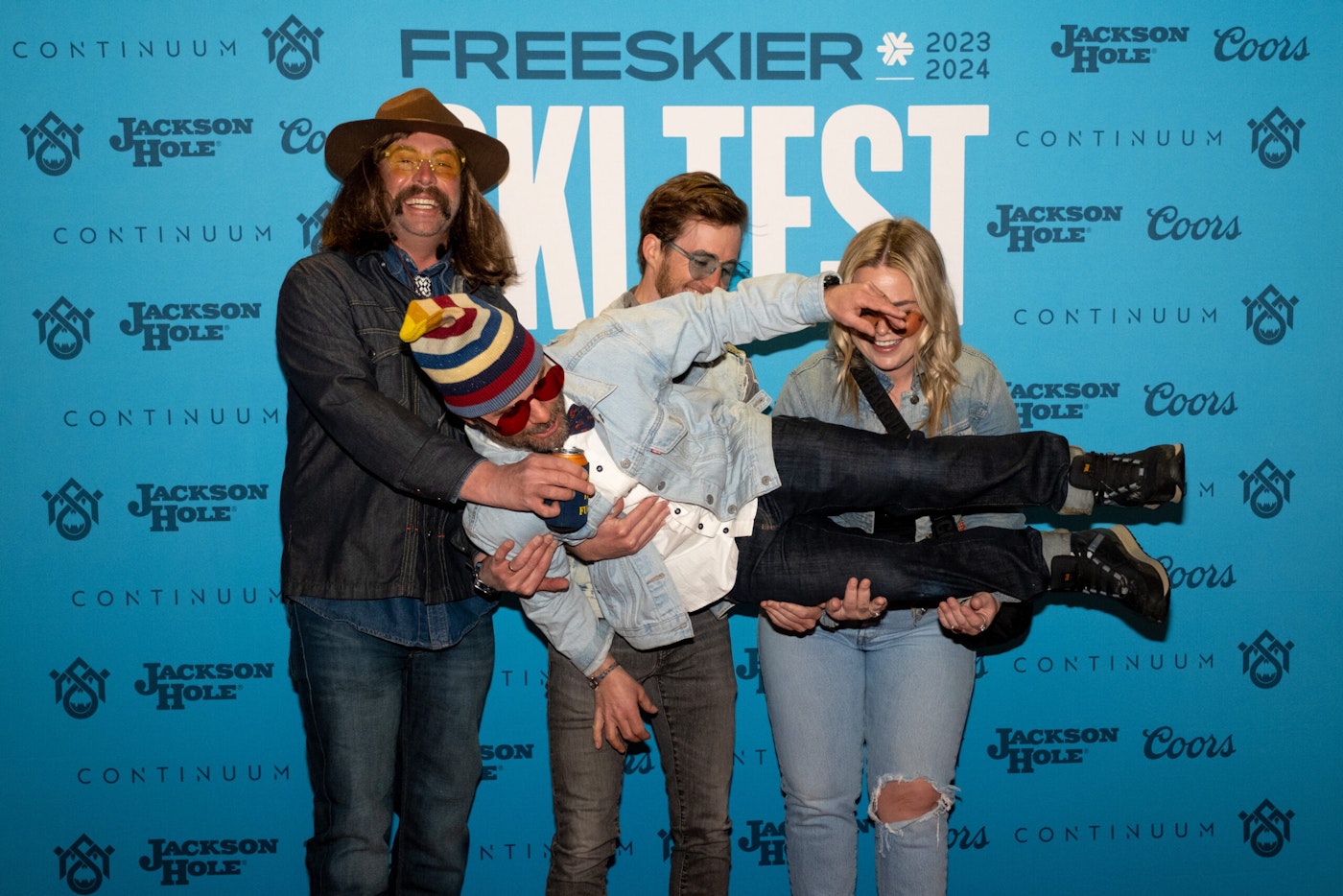 four people pose in front of FREESKIER banner