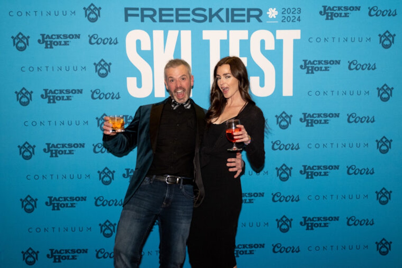 2 people pose in front of FREESKIER banner