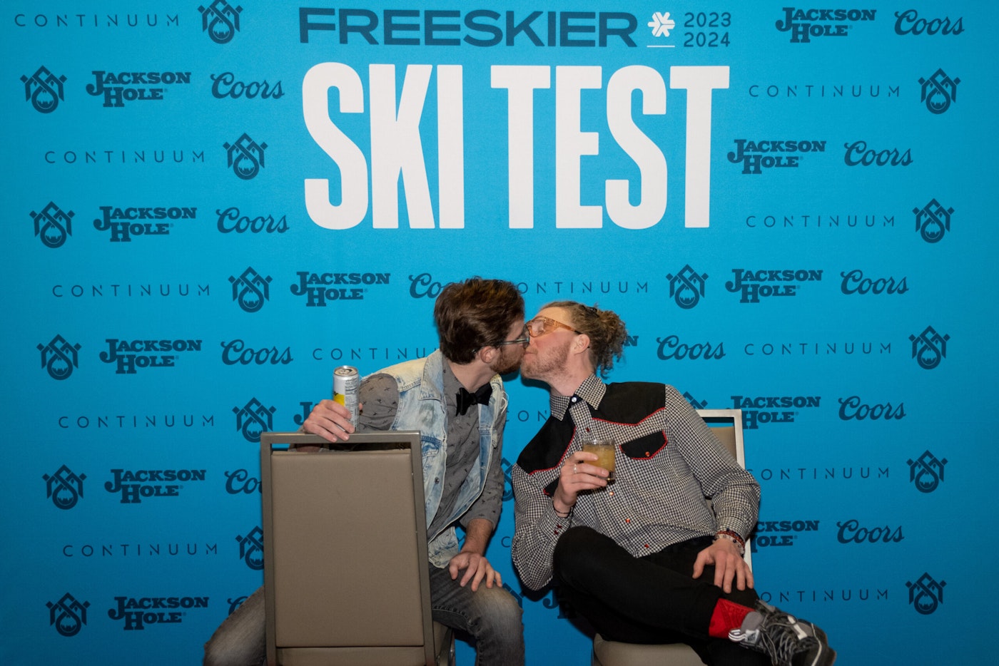 2 people pose in front of FREESKIER banner