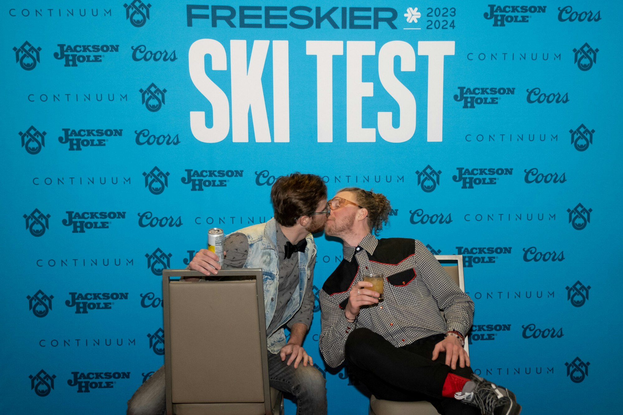 2 people pose in front of FREESKIER banner