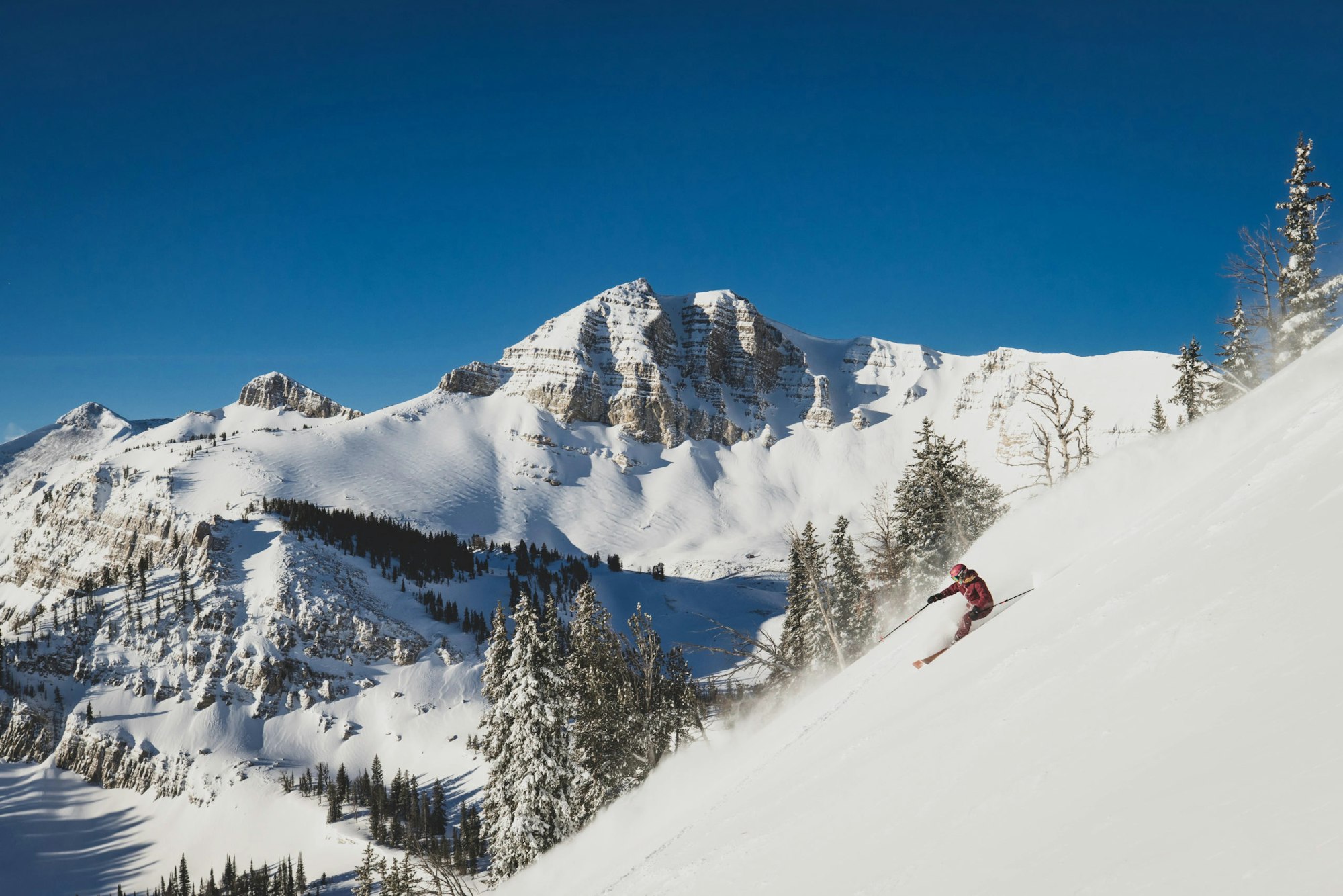 Skier skis down a steep slope in deep snow at Jackson Hole Mountain Resort