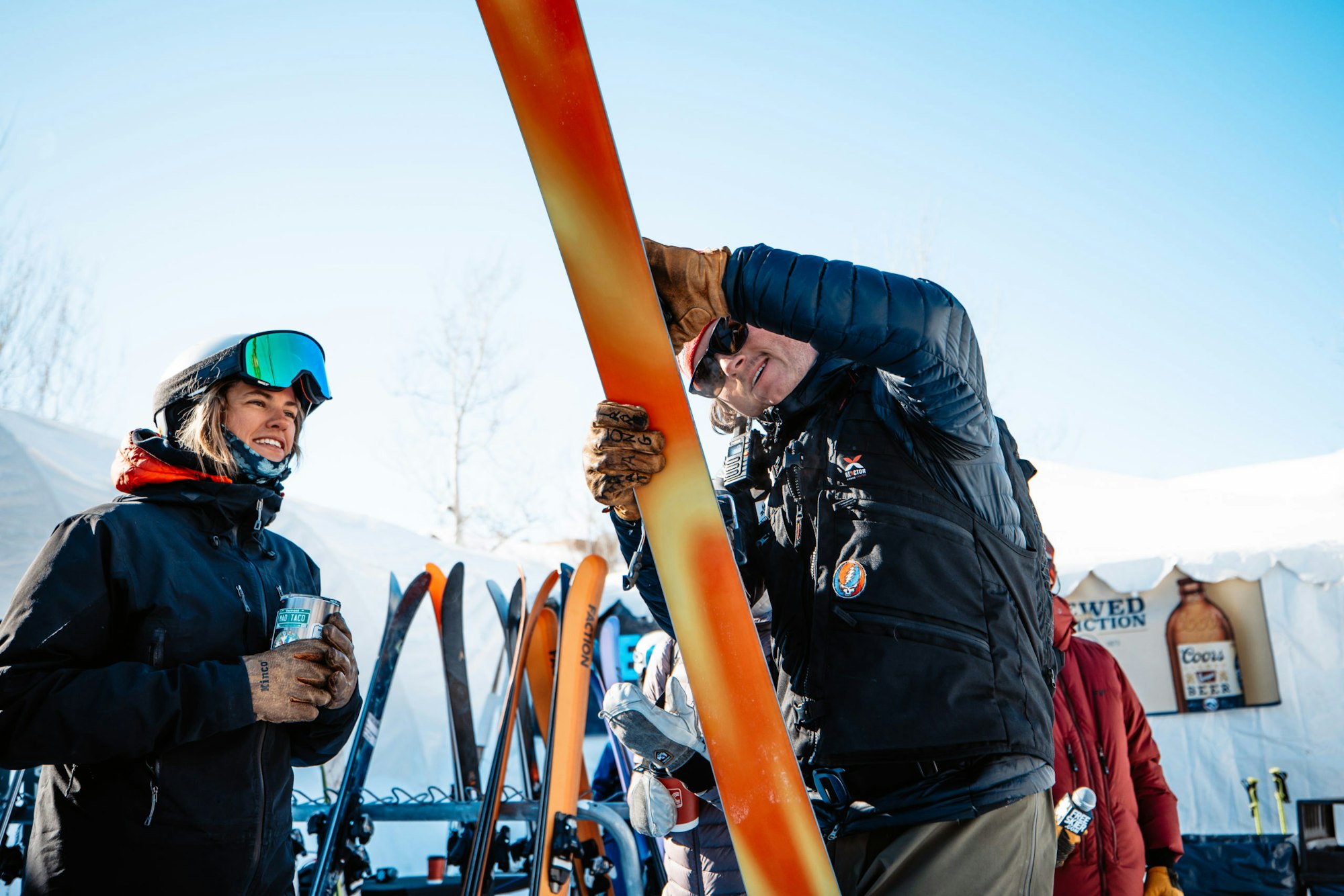 Skier watches man loop at the top sheet of a ski