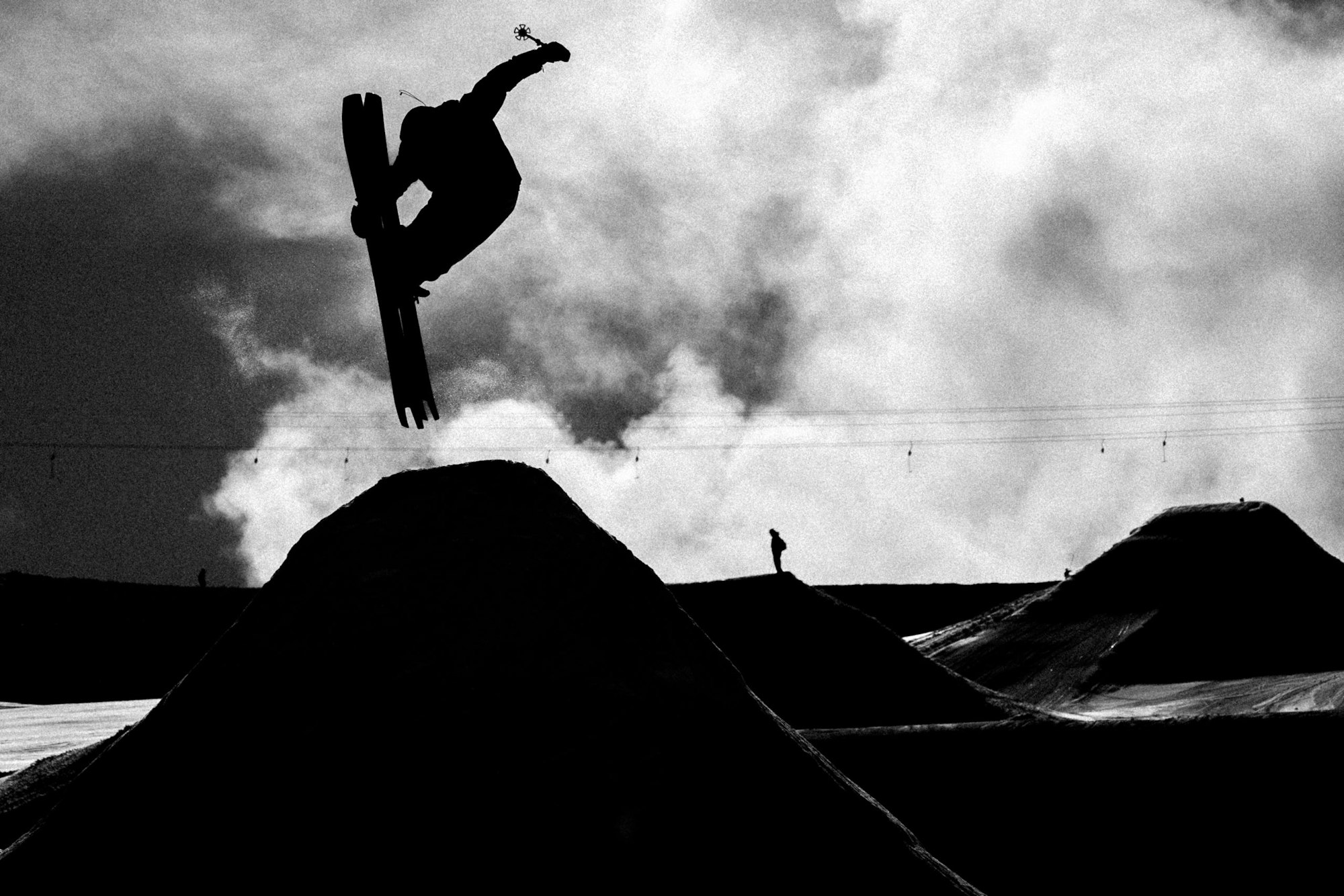 Skier jumps off a ledge grabbing the front of their skis