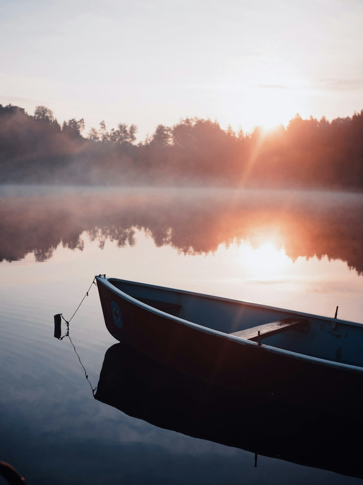 Canoe in a misty lake at dawn