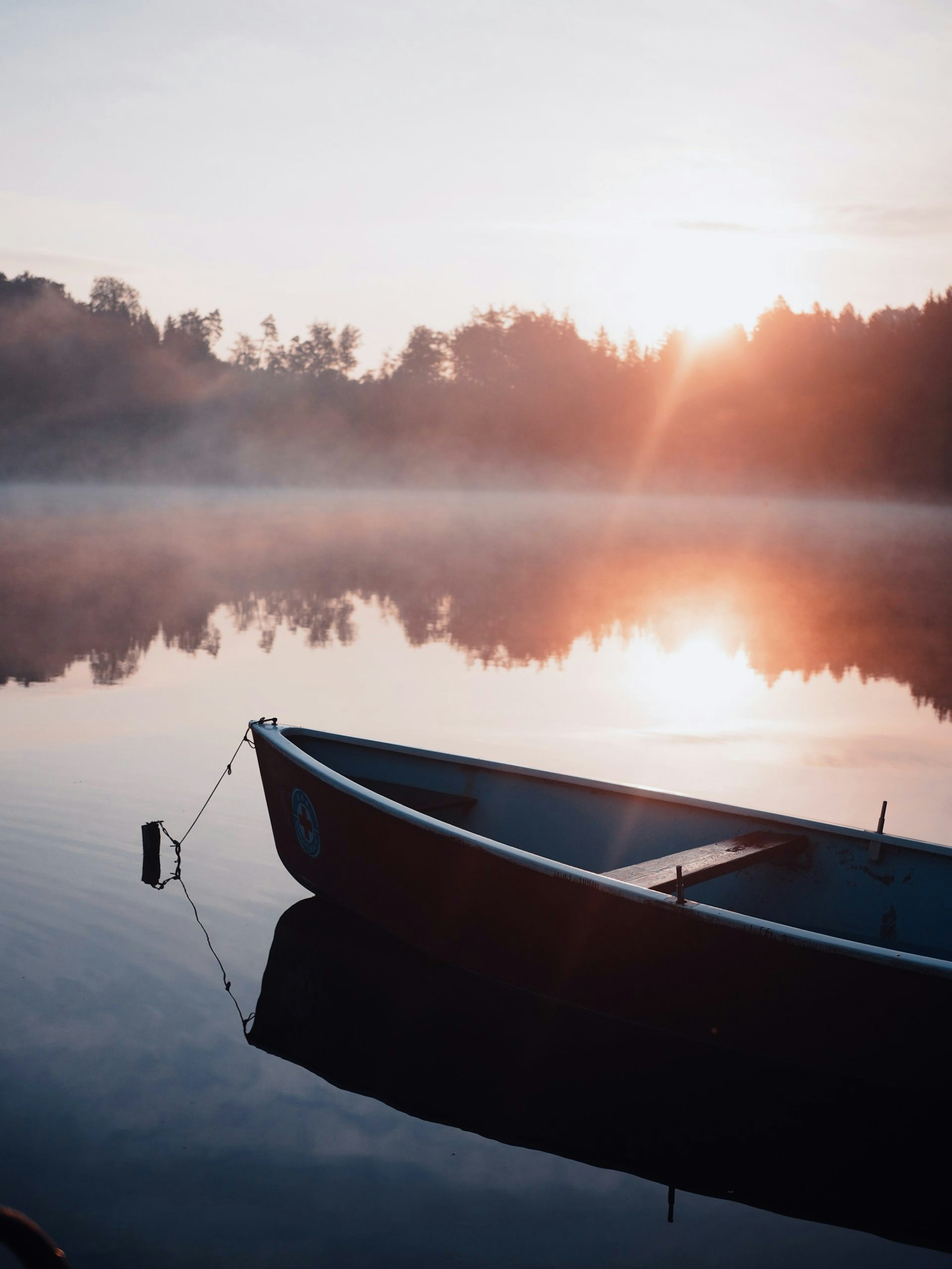 Canoe in a misty lake at dawn