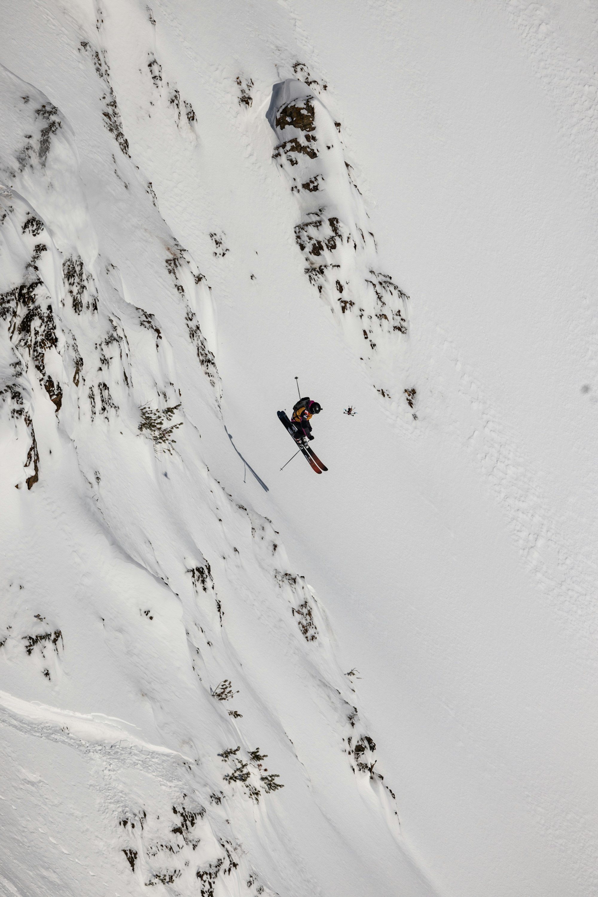 Skier catches air off a snowy rock