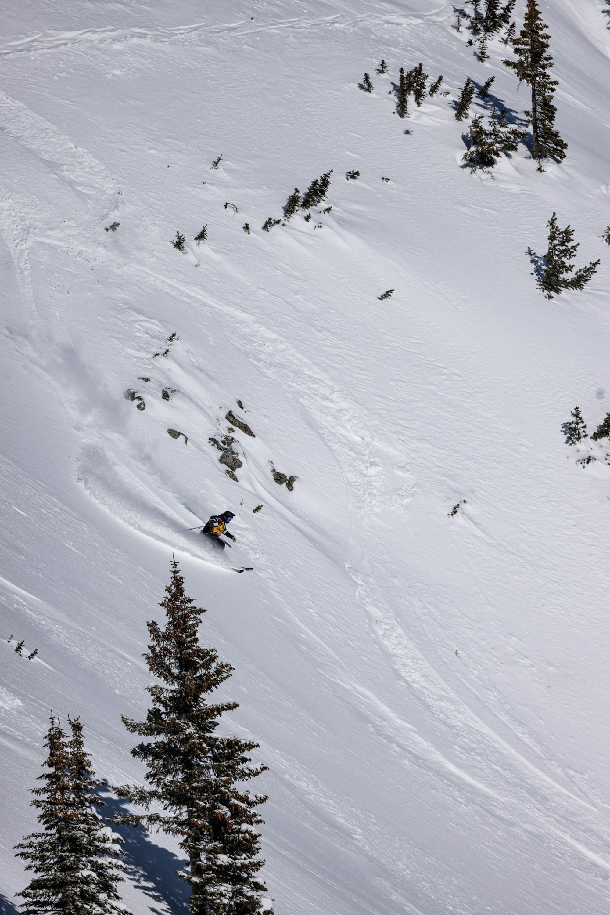 Skier makes a turn through deep powder snow