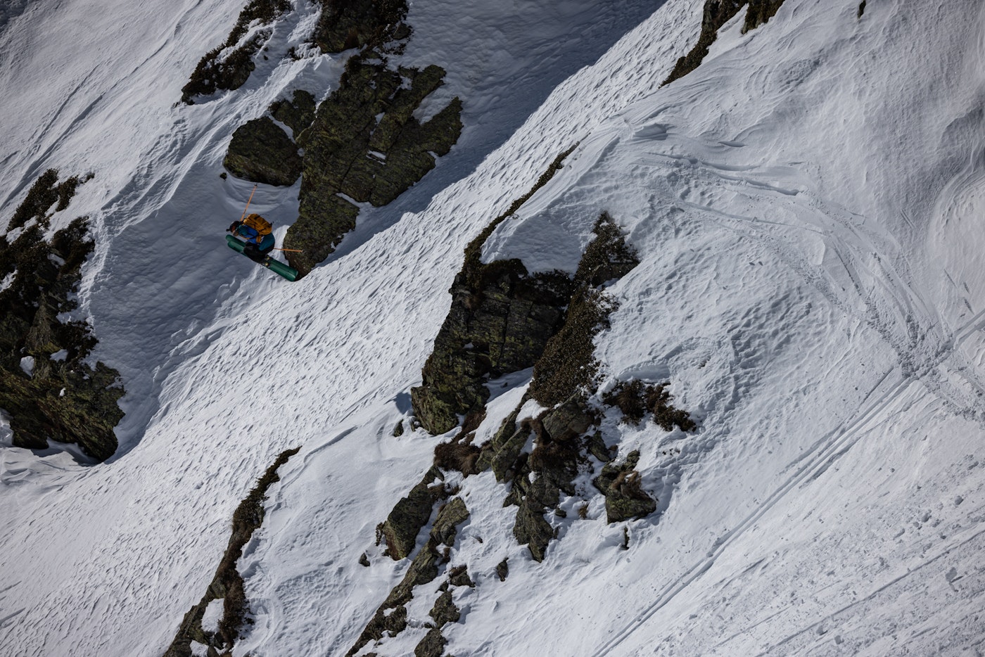 Freeride world tour skier jumping from a snowy rock