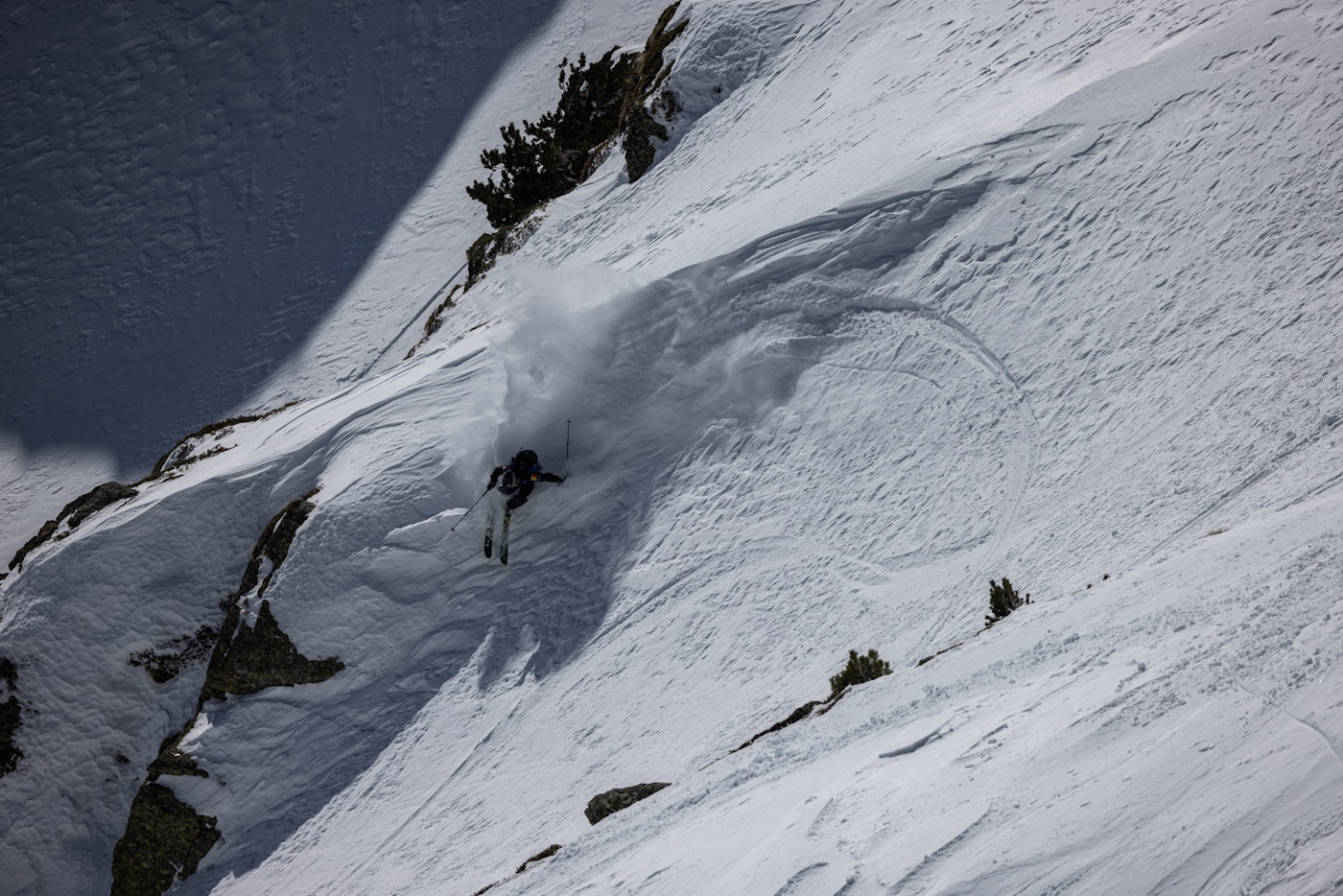 Freeride world tour skier turns sharply on a snowy slope