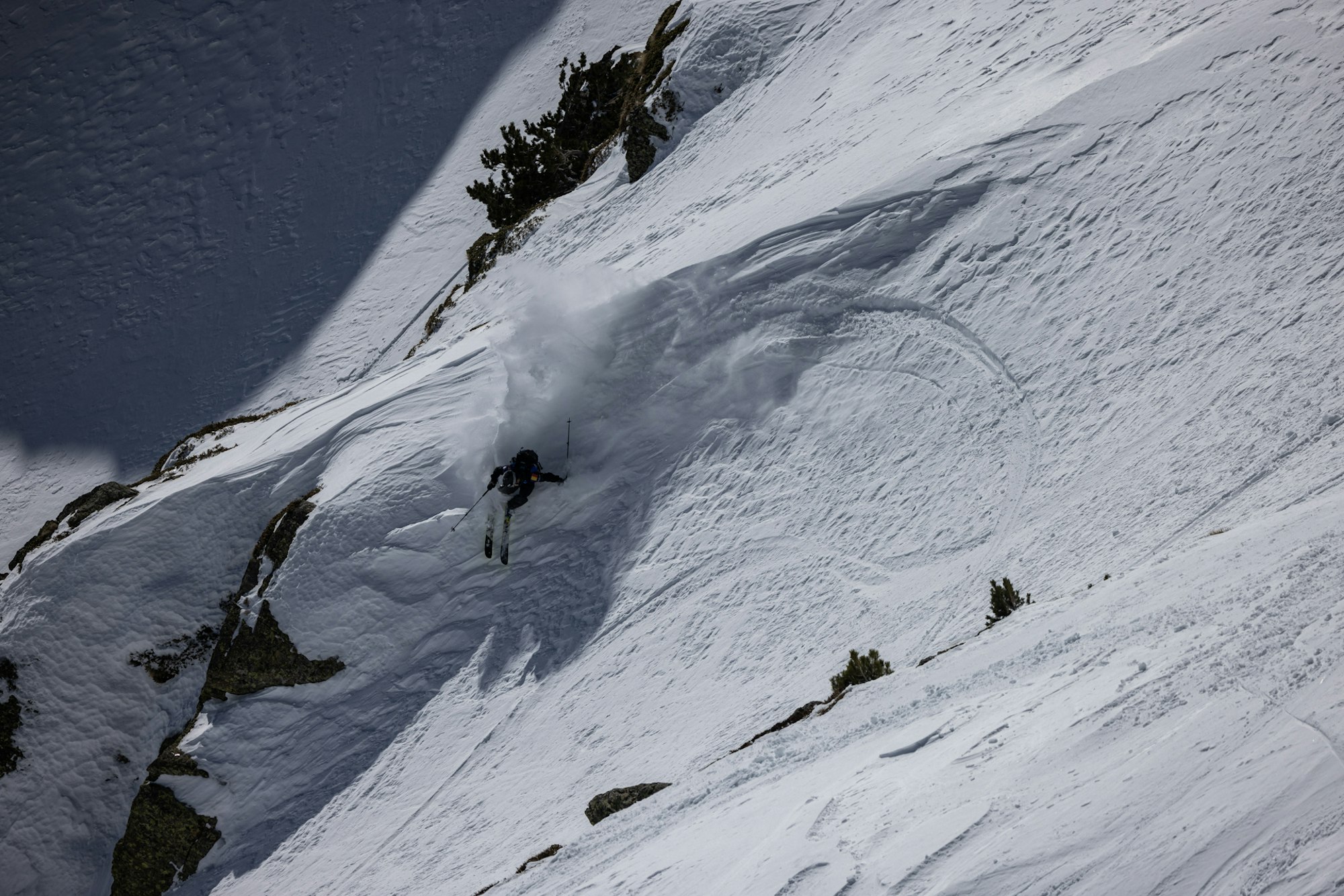 Freeride world tour skier turns sharply on a snowy slope