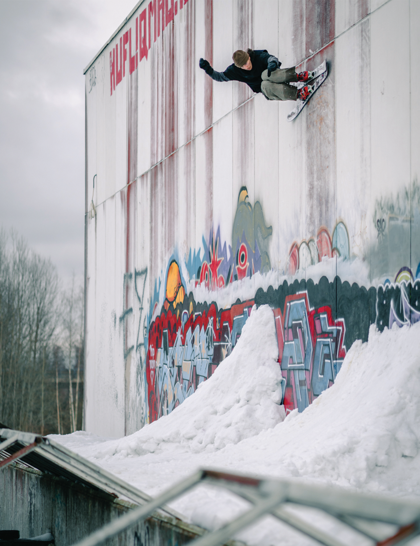 Skier Lauri Kvari slides on skis against a graffiti wall