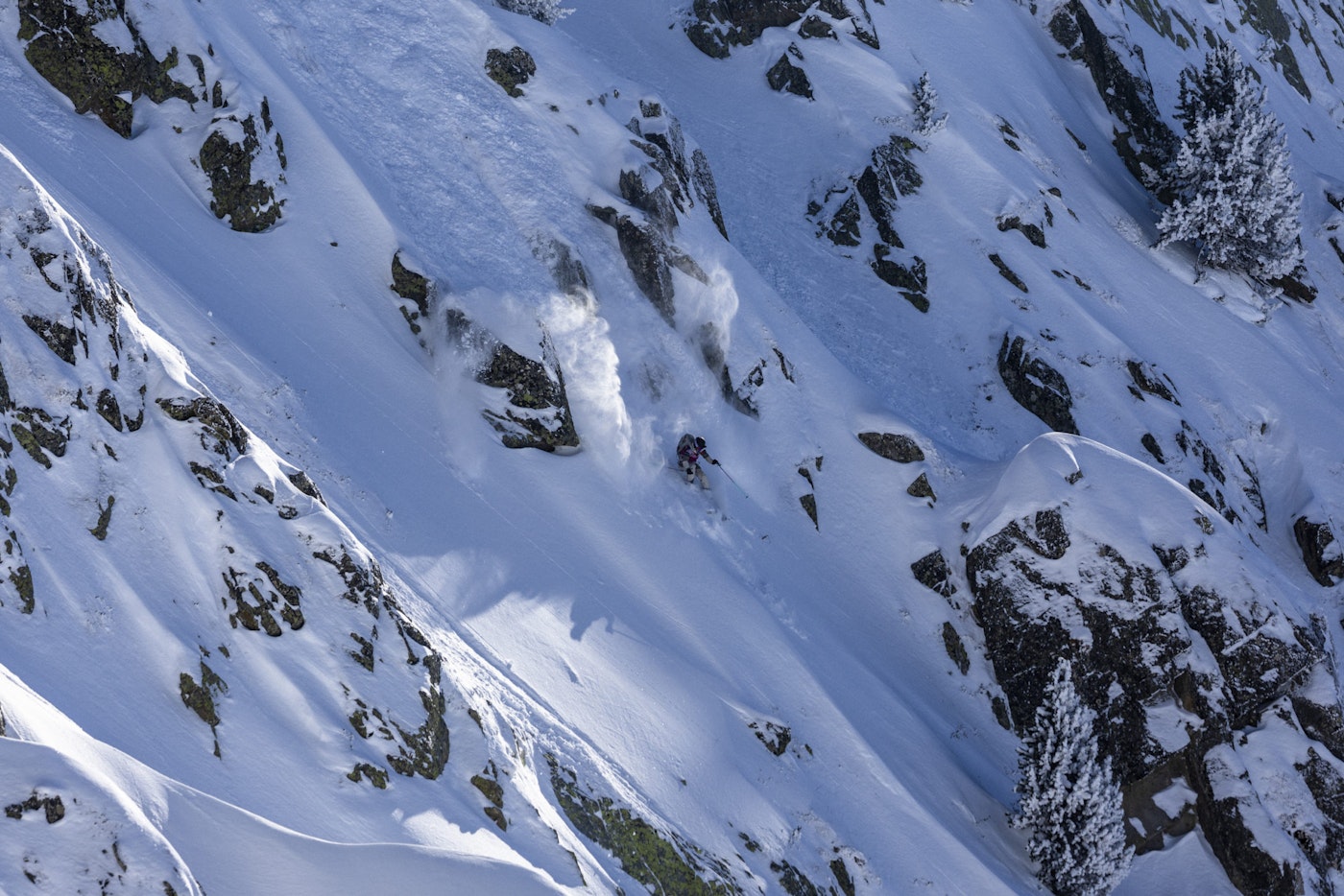 Freeride World Tour skier skis down a powdery rocky face