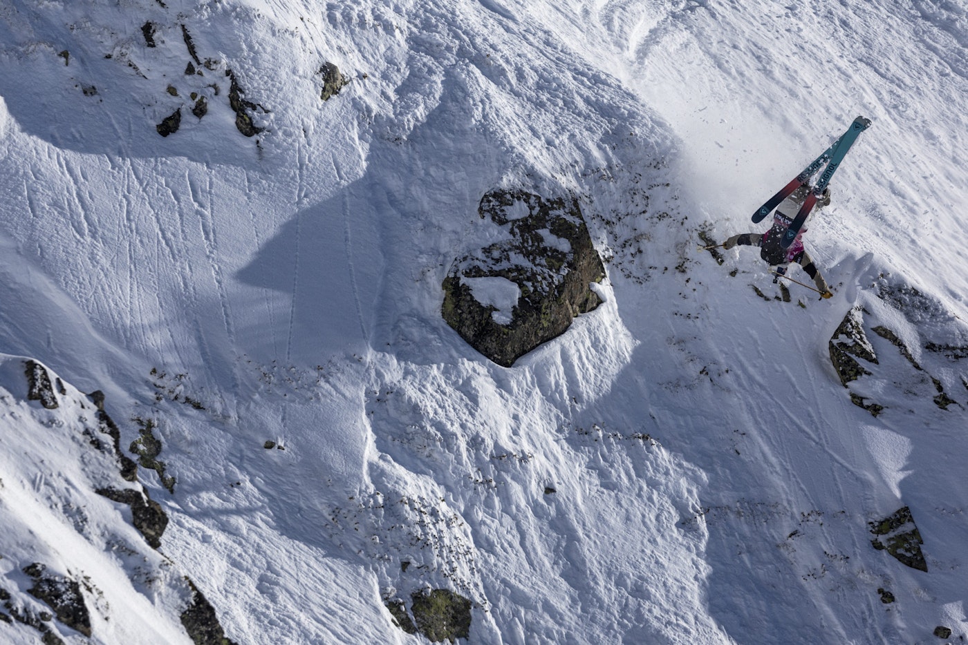 Freeride world tour skier flips off a snowy rock