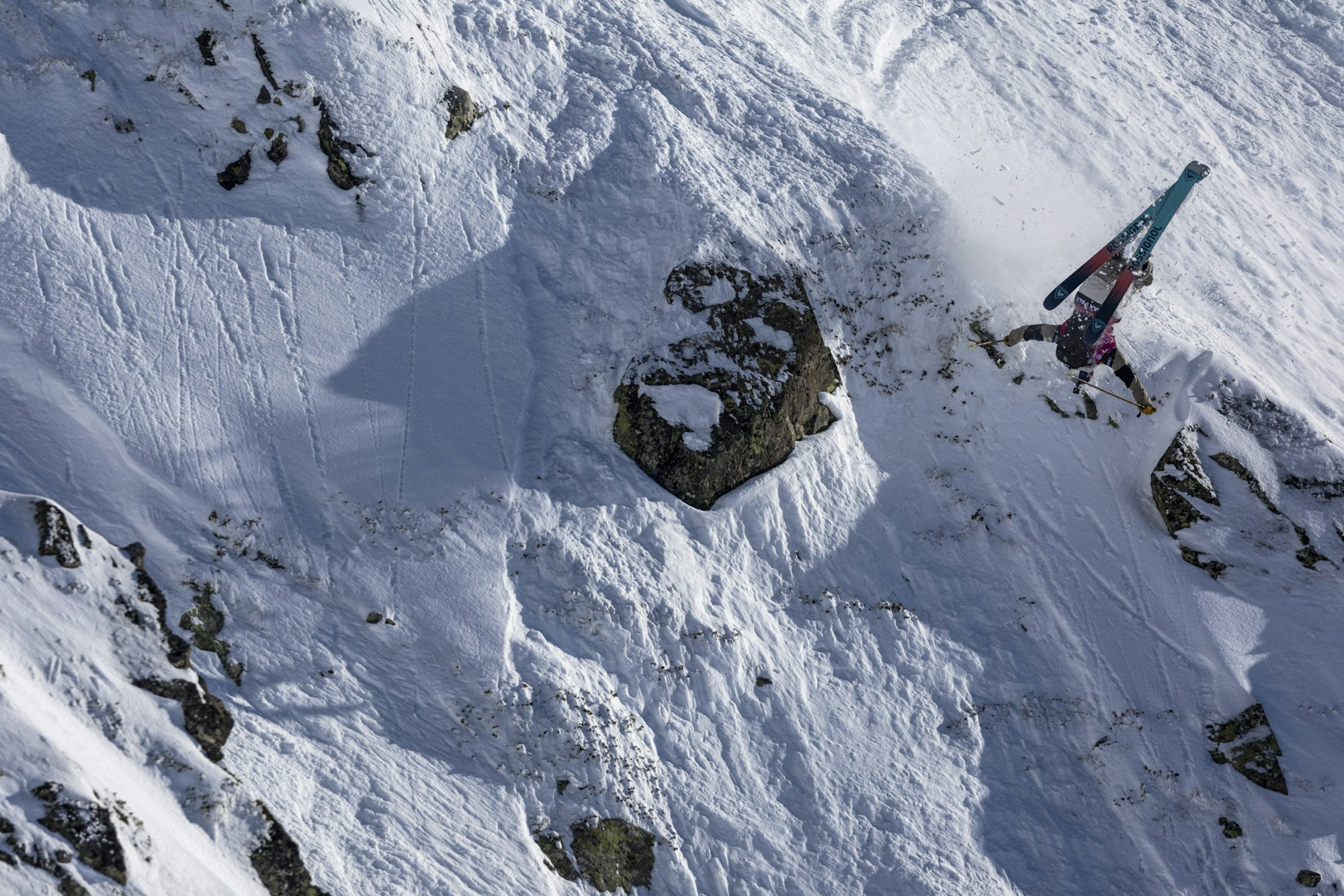 Freeride world tour skier flips off a snowy rock