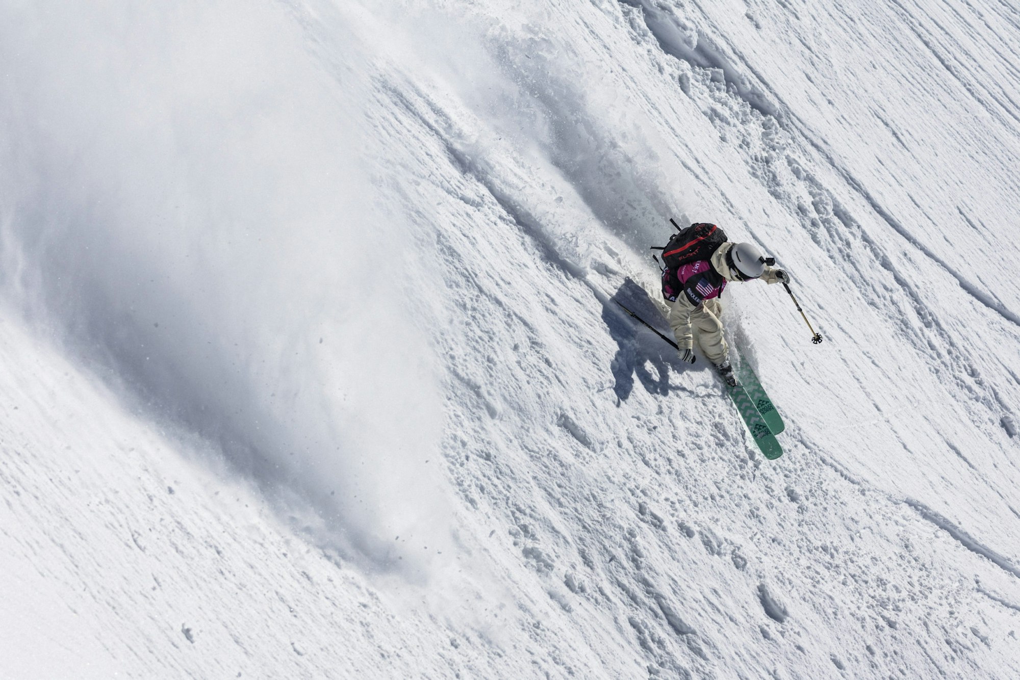 Freeride world tour skier turns down a snowy face