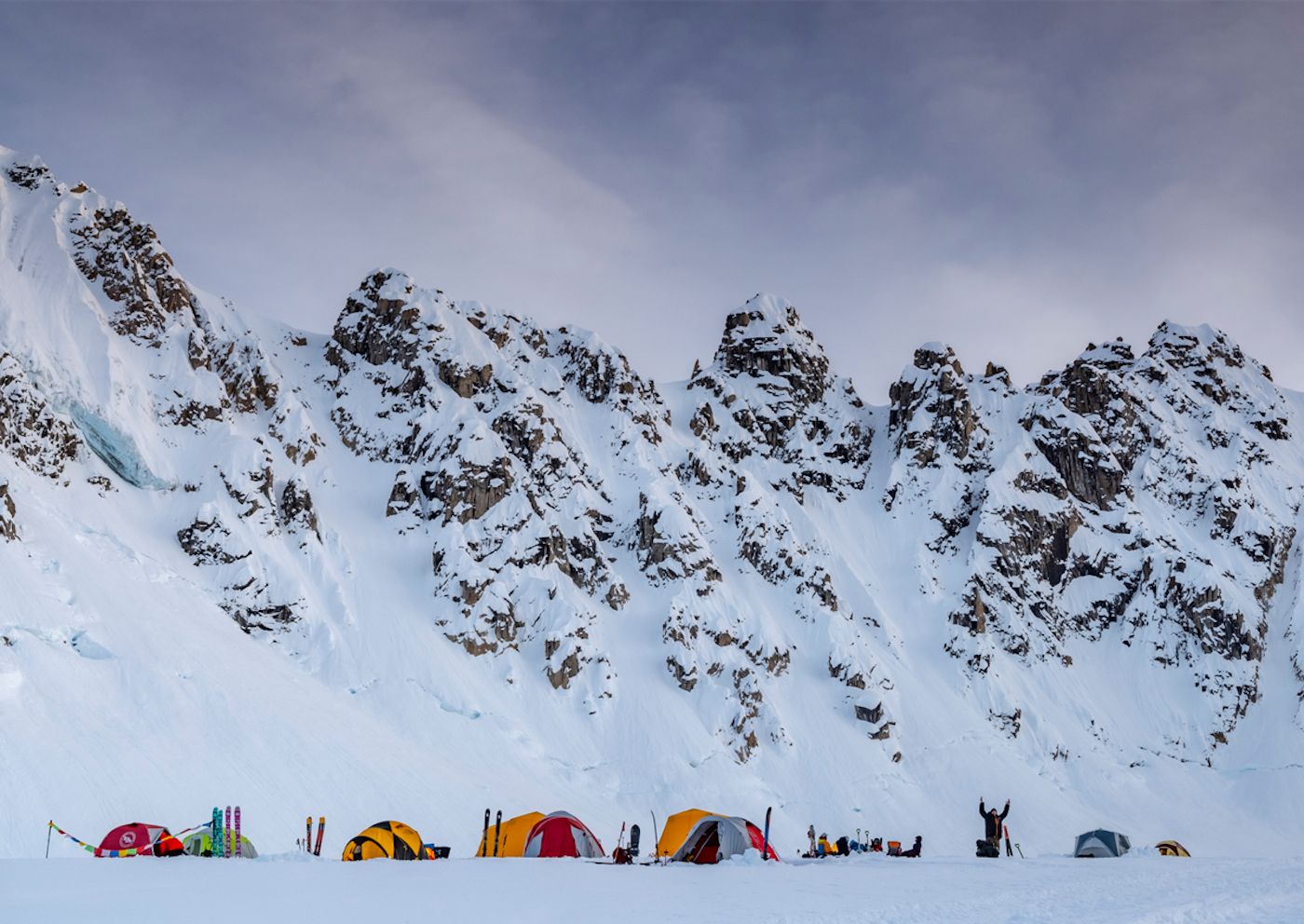 Skiers camping at the base of high peaks