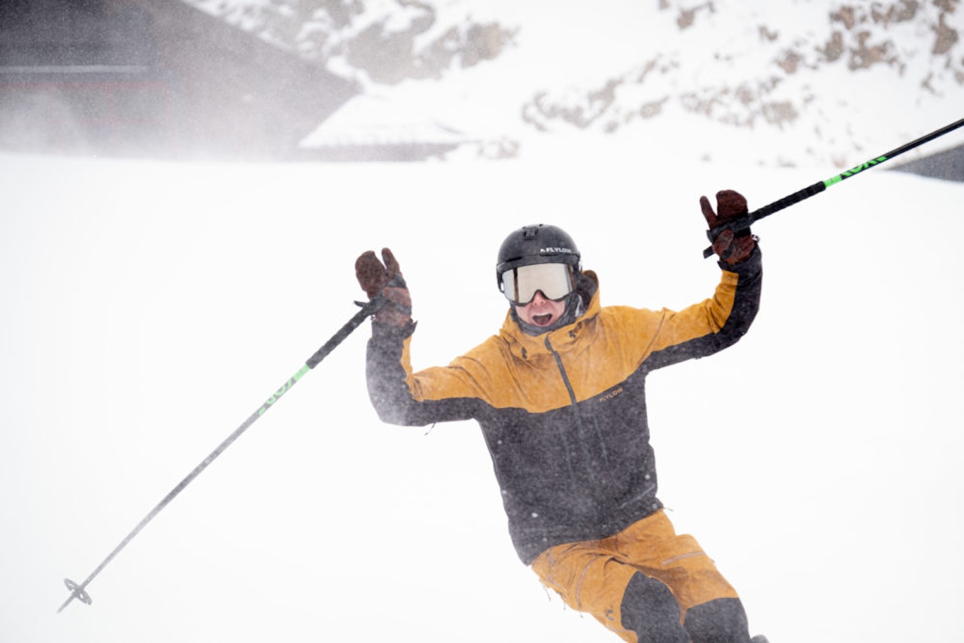 Skier skis down a snowy slope with his hands in the air
