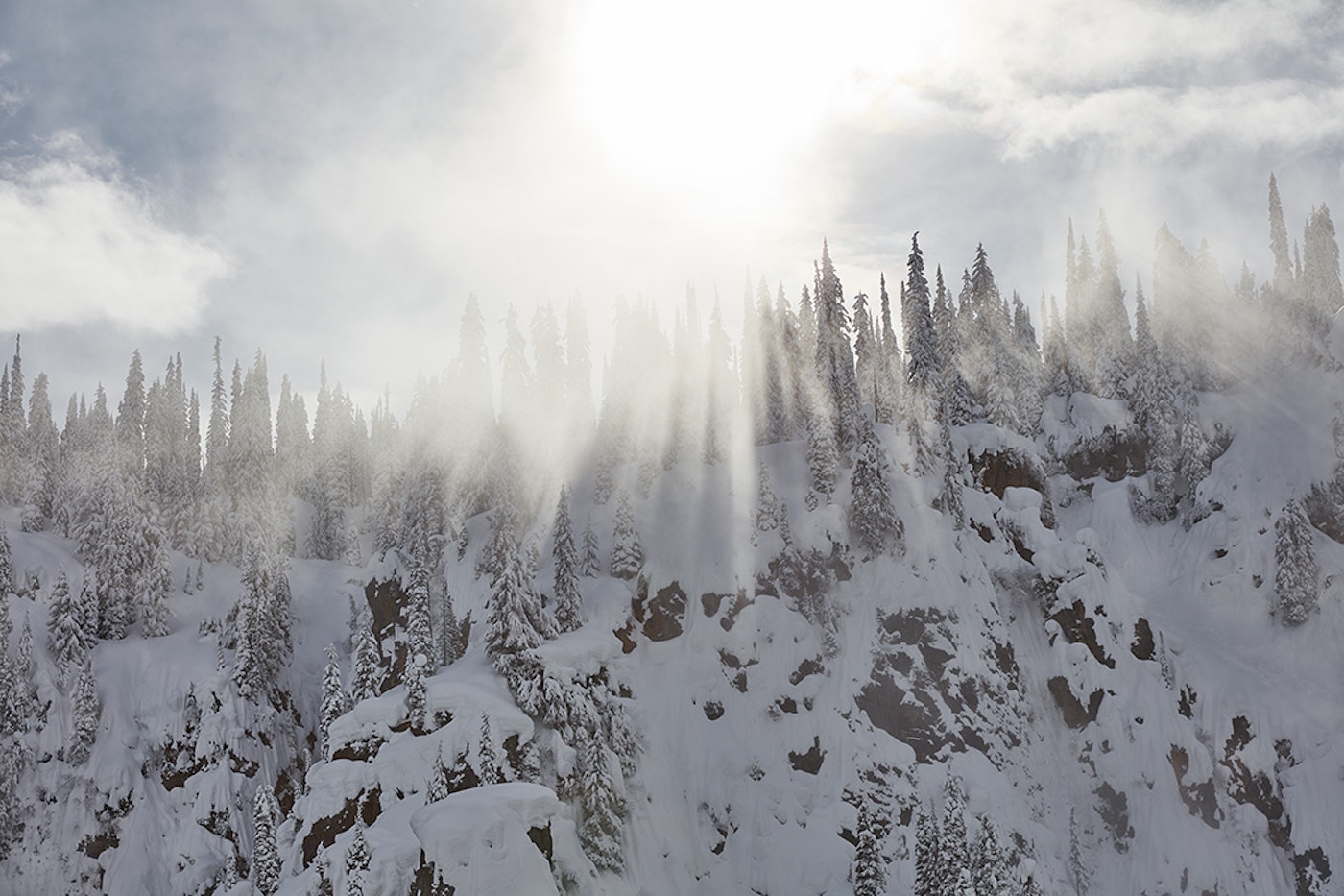 Beams of light press through the clouds at Eagle Pass Heliskiing