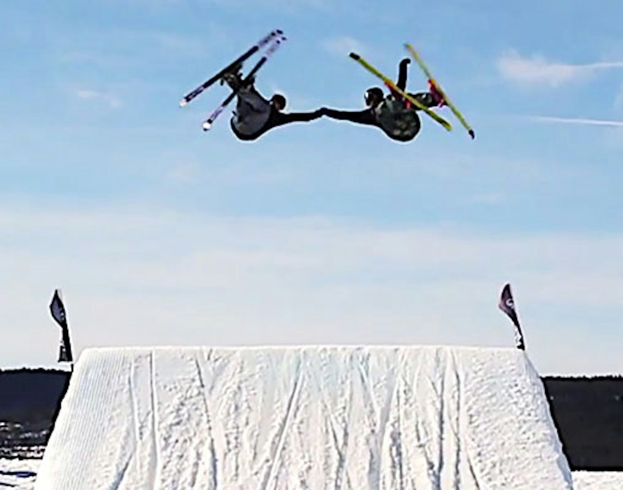 These synchronized skiers connected for well-timed, mid-air fist bump