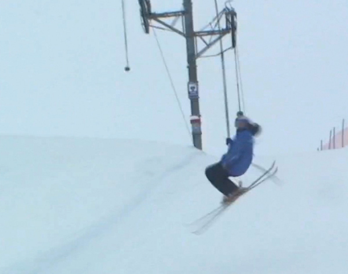 Skier stomps uphill double flatspin while riding Poma lift