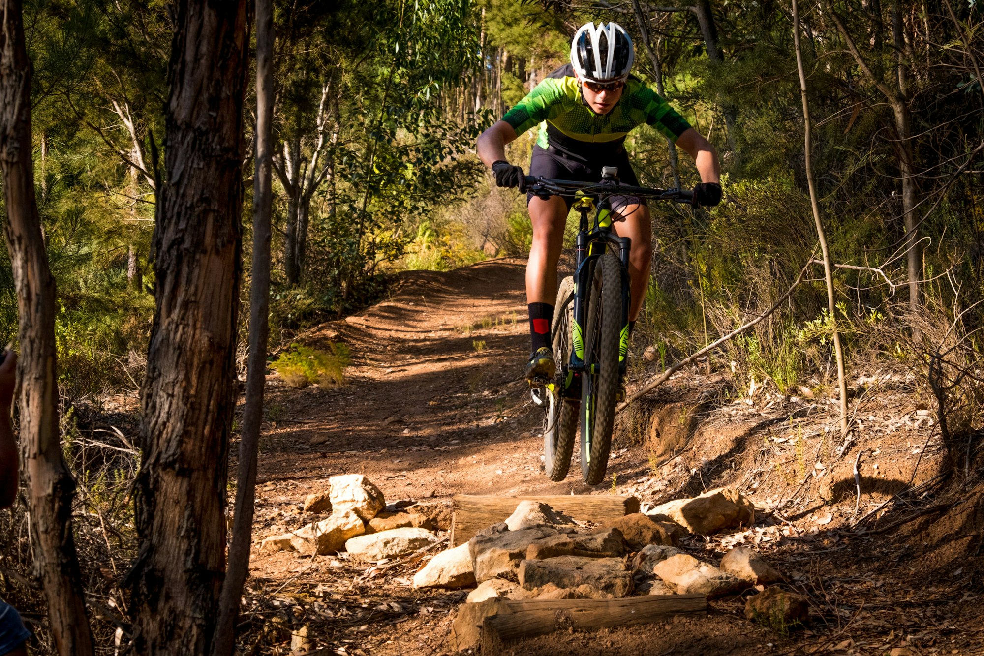 A mountain biker speeds down a technical rocky trail