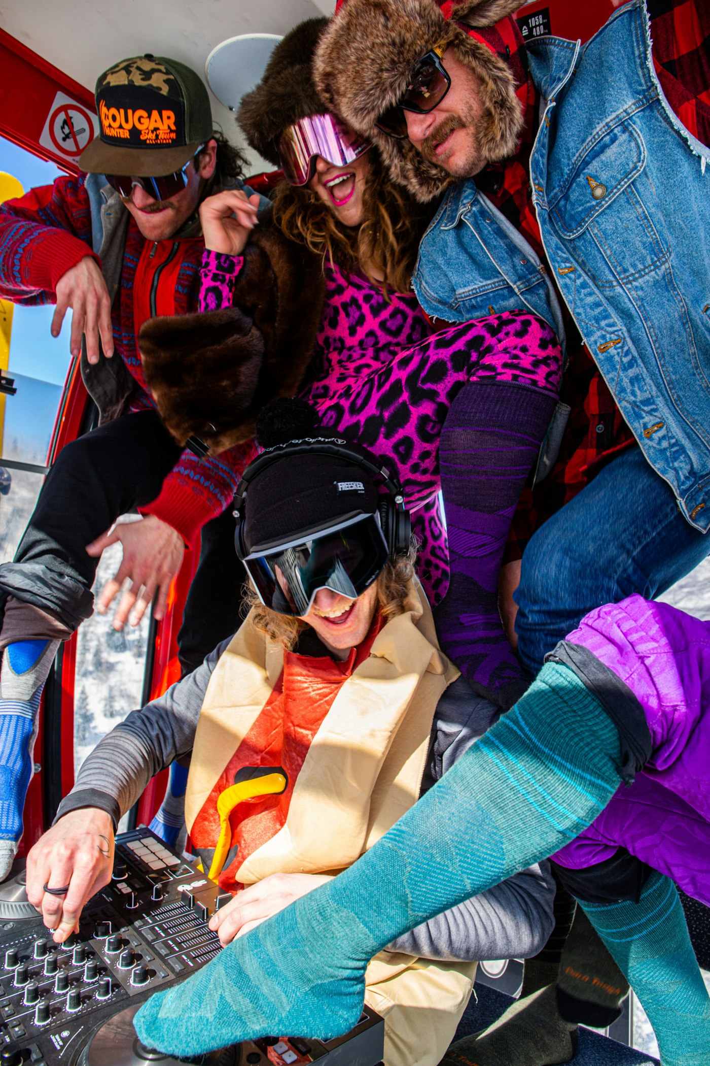 Skiers with a DJ deck in a gondola