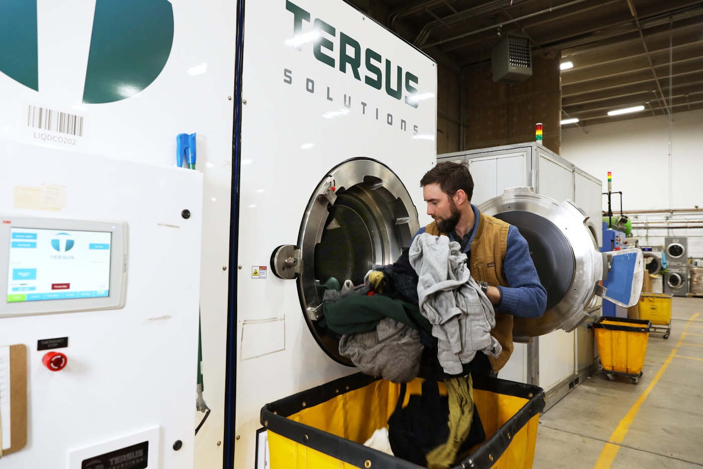 Tersus employee puts clothes in the CO2 washing machine