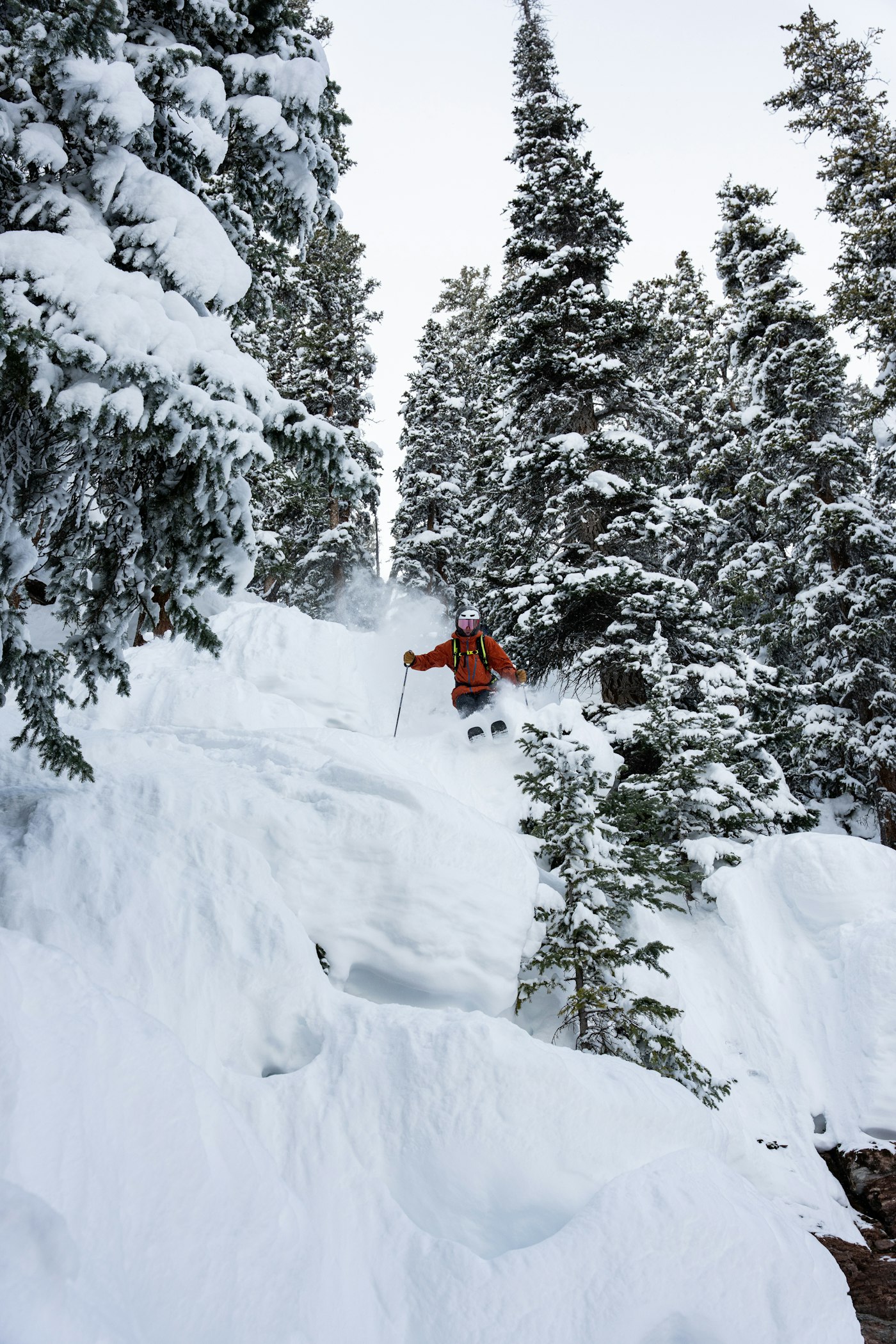 skier skiing off a snowy cliff