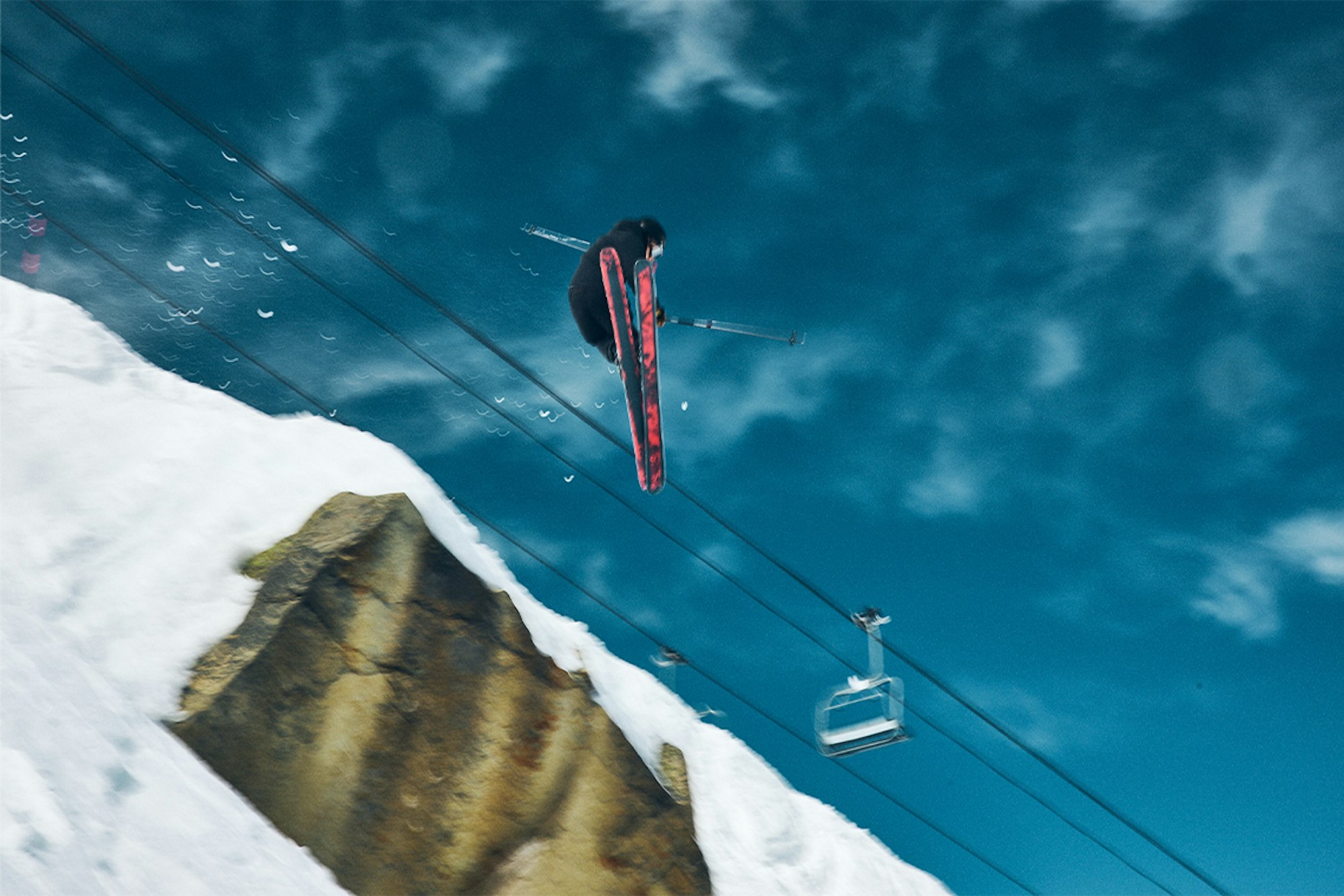Skier jumps under a chairlift