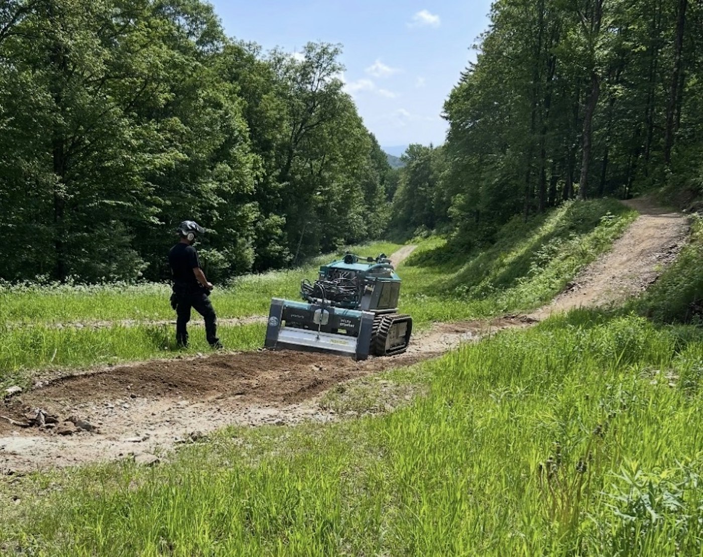 Trail crew worker controlling Trail Crusher machine.