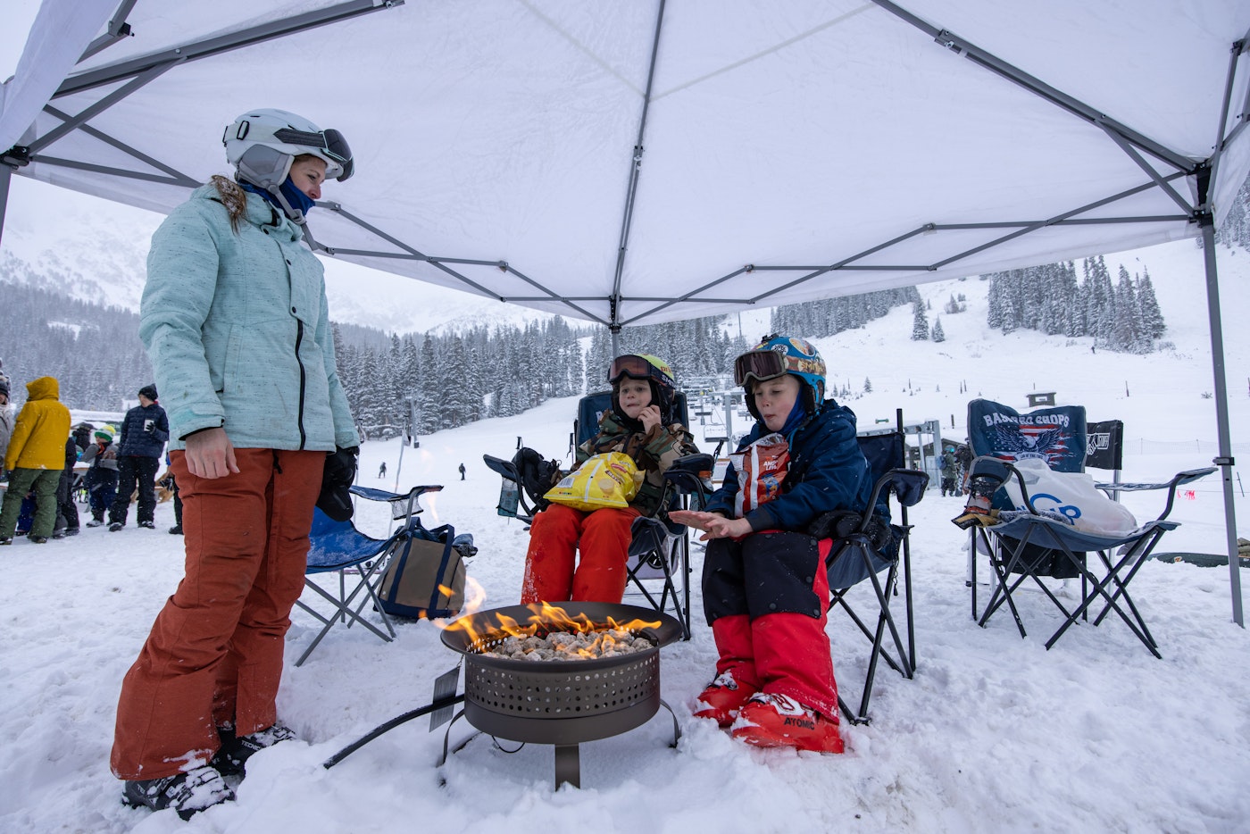 Mom giving kids the full tailgating expereince with a fire at Arapahoe Basin, Colorado.