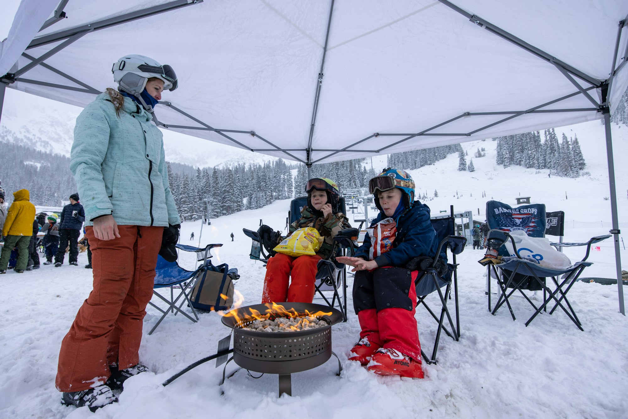 Mom giving kids the full tailgating expereince with a fire at Arapahoe Basin, Colorado.