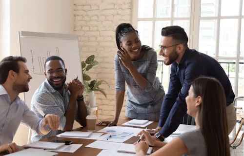 The photo shows a workplace with employees of different ethnicities