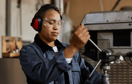 Machinery operator in factory with eye protection