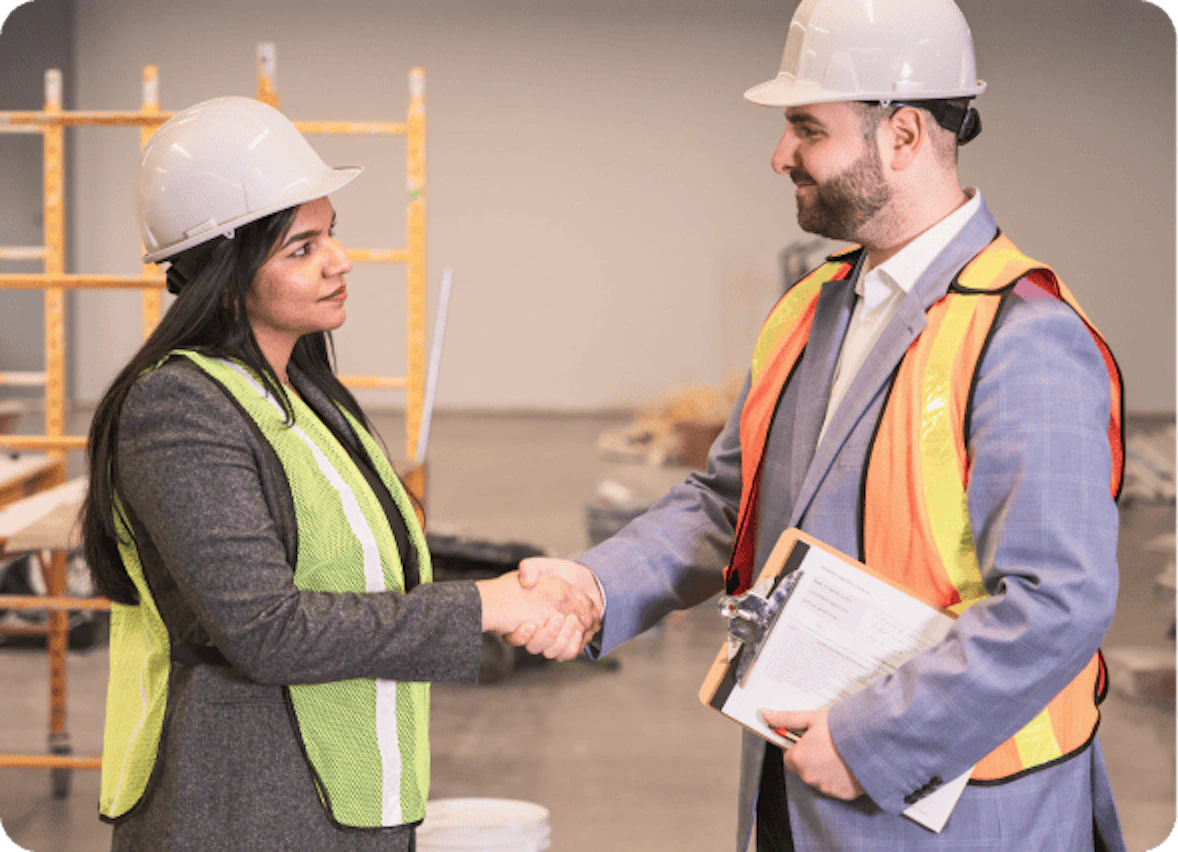 Health and safety consultant shaking hands with a client at a worksite