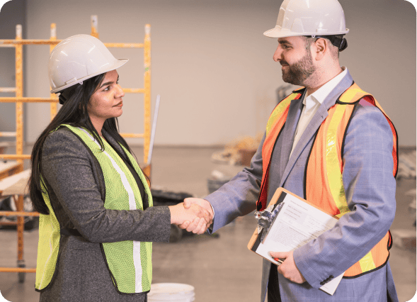 Health and safety consultant shaking hands with a client at a worksite