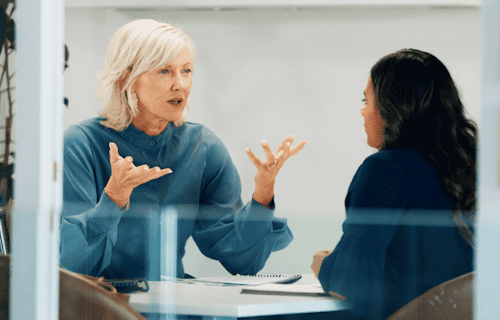 An employer providing feedback to an employee in a meeting room