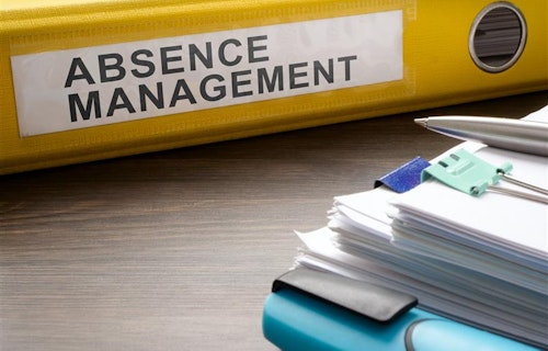 Close-up of an HR folder titled Absence Management lying on a table.