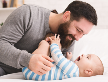 Image of a man playing with his infant.