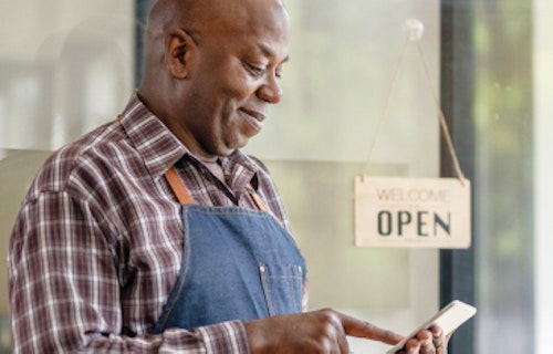 A small business owner in front of his shop