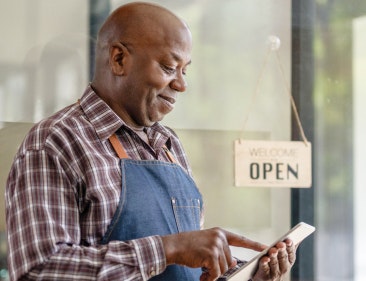 A small business owner in front of his shop