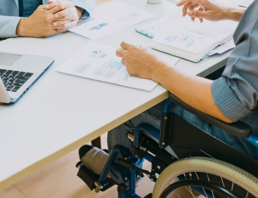 An injured worker in a wheelchair filling out paperwork.