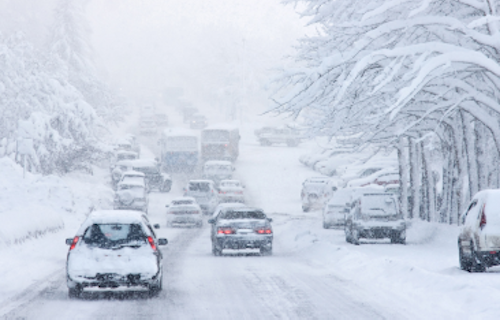 Traffic on the road moving slowly during heavy snowfall