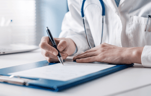 A doctor signing a sick note in a clinic.