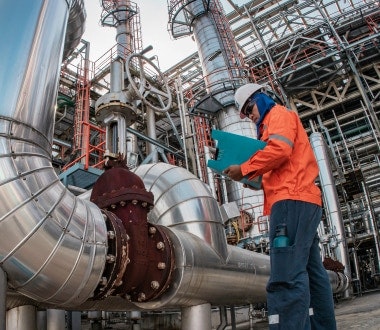 An oil and gas worker inspecting the worksite