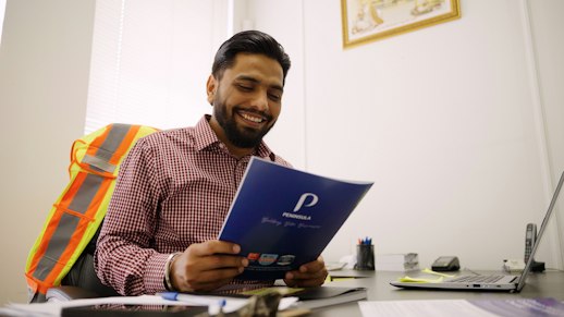Image of Regal Forklift owner Rajinder Singh sitting in his office, reading a Peninsula document.