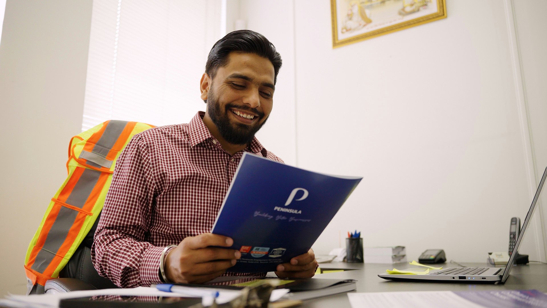 Image of Regal Forklift owner Rajinder Singh sitting in his office, reading a Peninsula document.