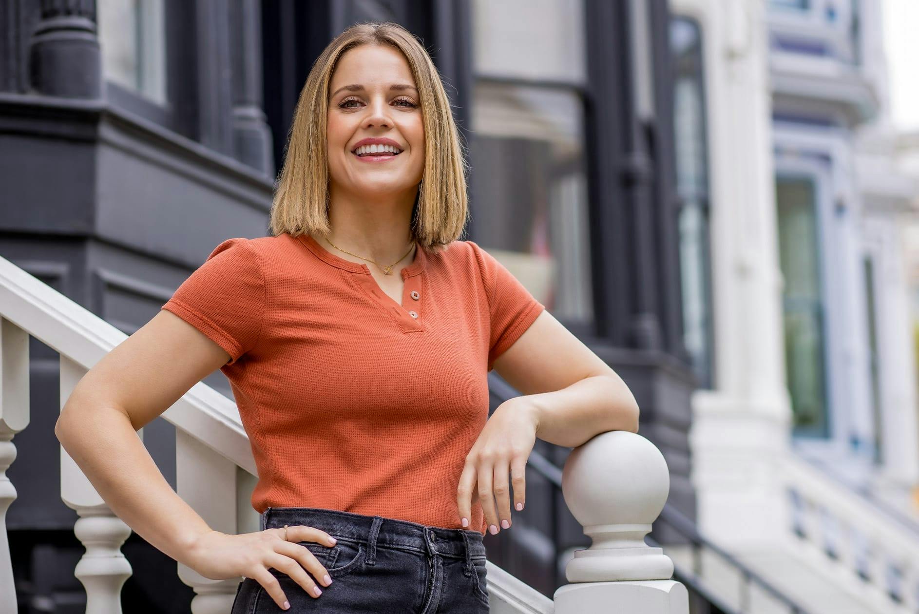 woman smiling while leaning on stair railling