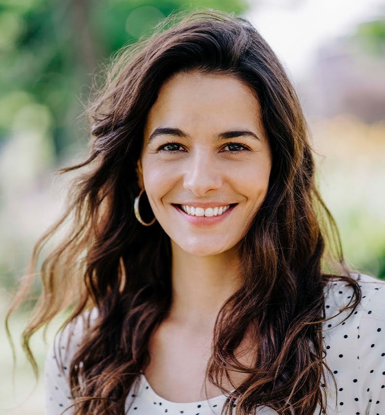 woman with wavy hair smiling forward