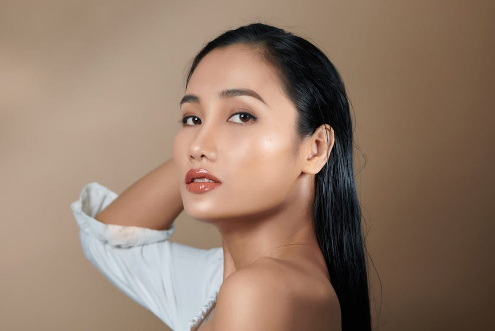 woman facing to the side with her hand behind her head